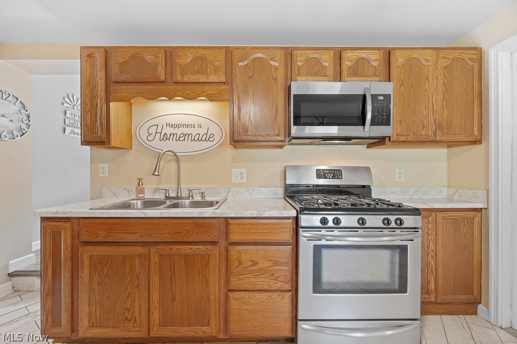 2400 Sunnybrook Road Mogadore, OH 44260 - Photo 11 of 50 Kitchen with light tile patterned flooring, appliances with stainless steel finishes, and sink