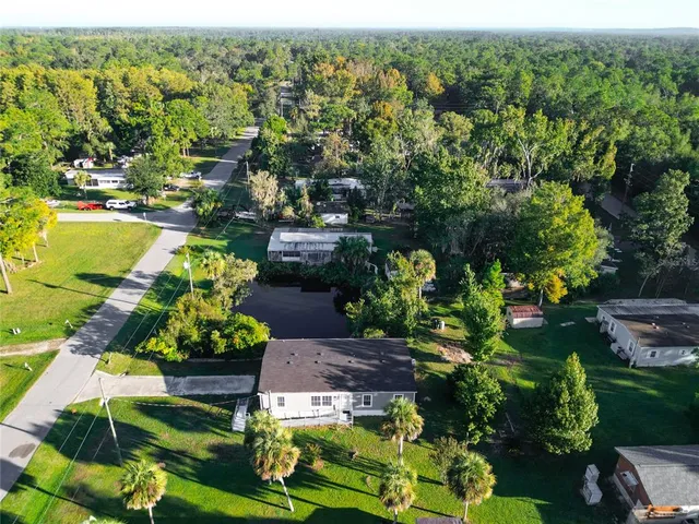 an aerial view of a house with a garden and lake view