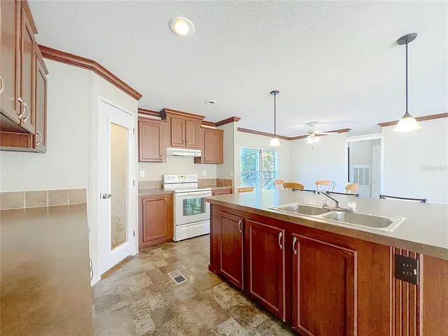 a kitchen with a sink refrigerator and cabinets