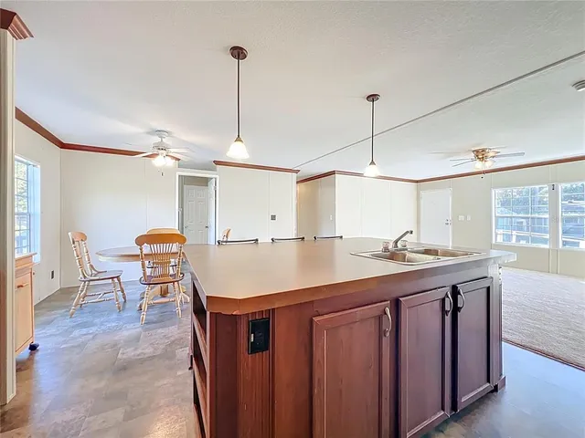 a kitchen with a table chairs sink and wooden floor