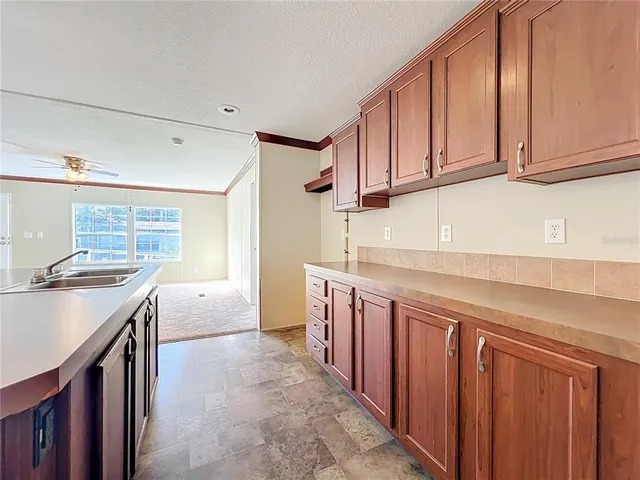 a kitchen with granite countertop a sink stove and cabinets