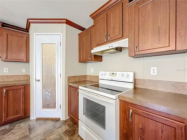 a kitchen with stainless steel appliances granite countertop a stove a sink and a microwave