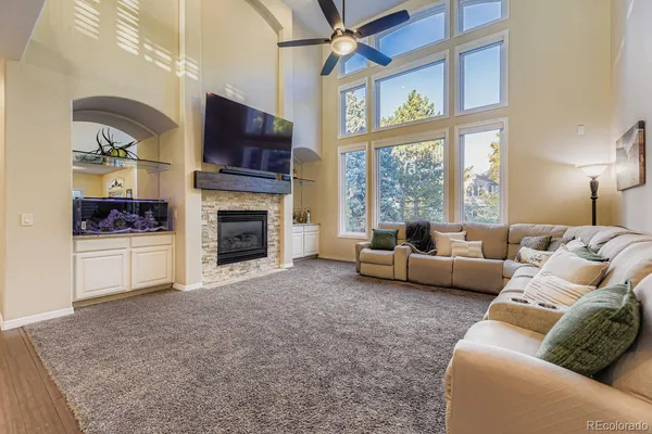 a living room with furniture a flat screen tv and a fireplace