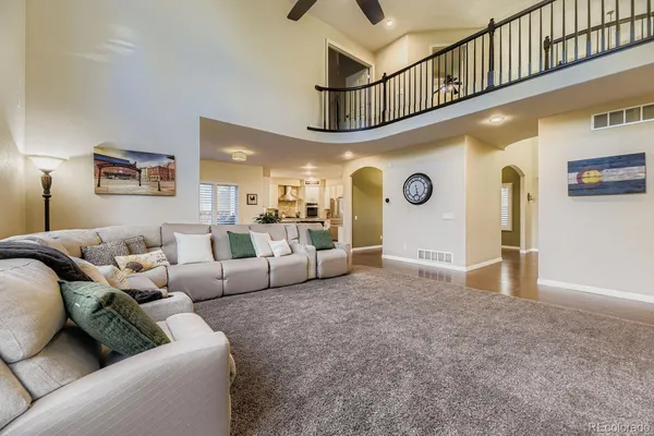 a living room with furniture and a ceiling fan