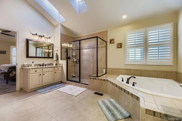 a bathroom with a granite countertop sink mirror vanity and bathtub