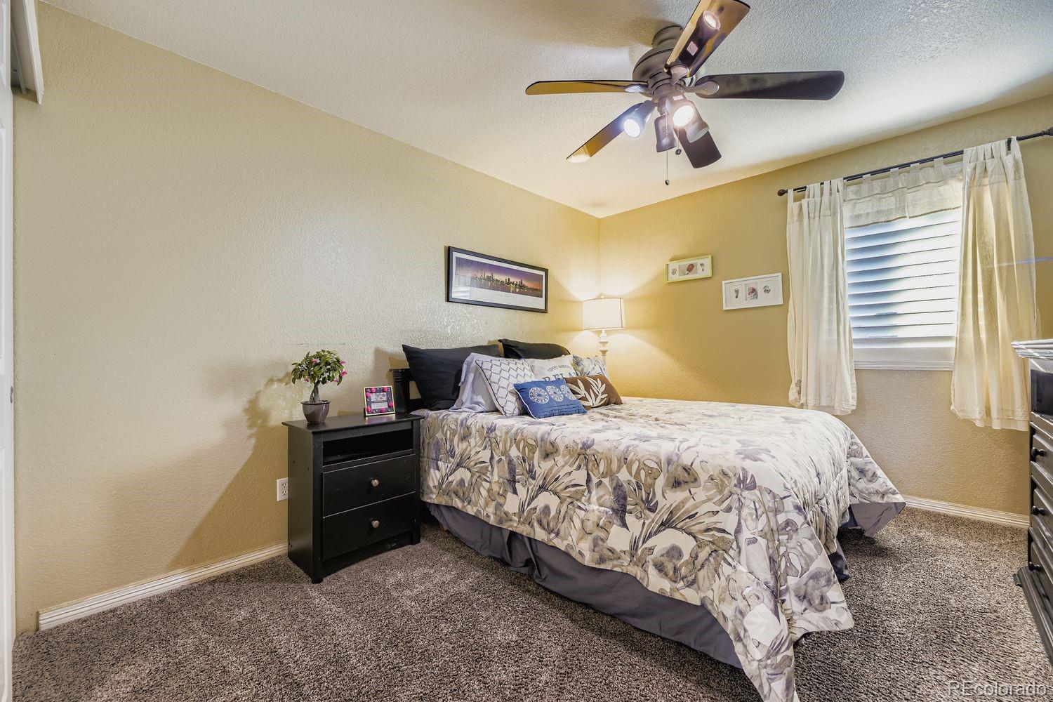 8356 Green Island Circle Lone Tree, CO 80124 - Photo 19 of 30 a bedroom with a bed and a chandelier