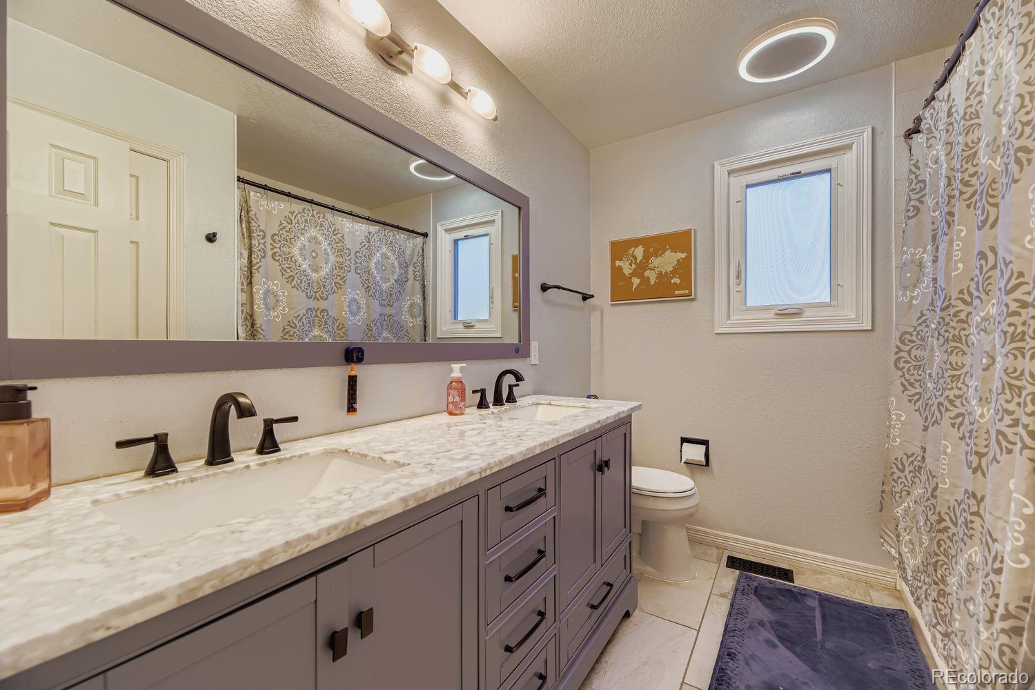 8356 Green Island Circle Lone Tree, CO 80124 - Photo 21 of 30 a bathroom with a granite countertop sink toilet and mirror