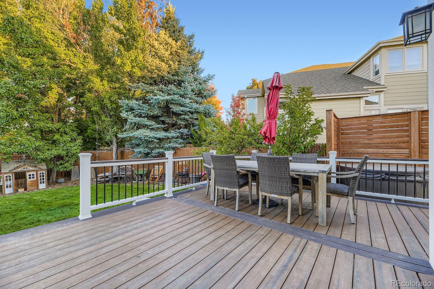 8356 Green Island Circle Lone Tree, CO 80124 - Photo 28 of 30 a view of a roof deck with table and chairs with wooden floor and fence