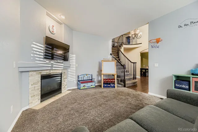 a living room with furniture a flat screen tv and a fireplace