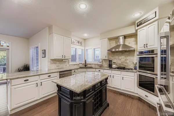 a kitchen with granite countertop a sink appliances cabinets and counter space