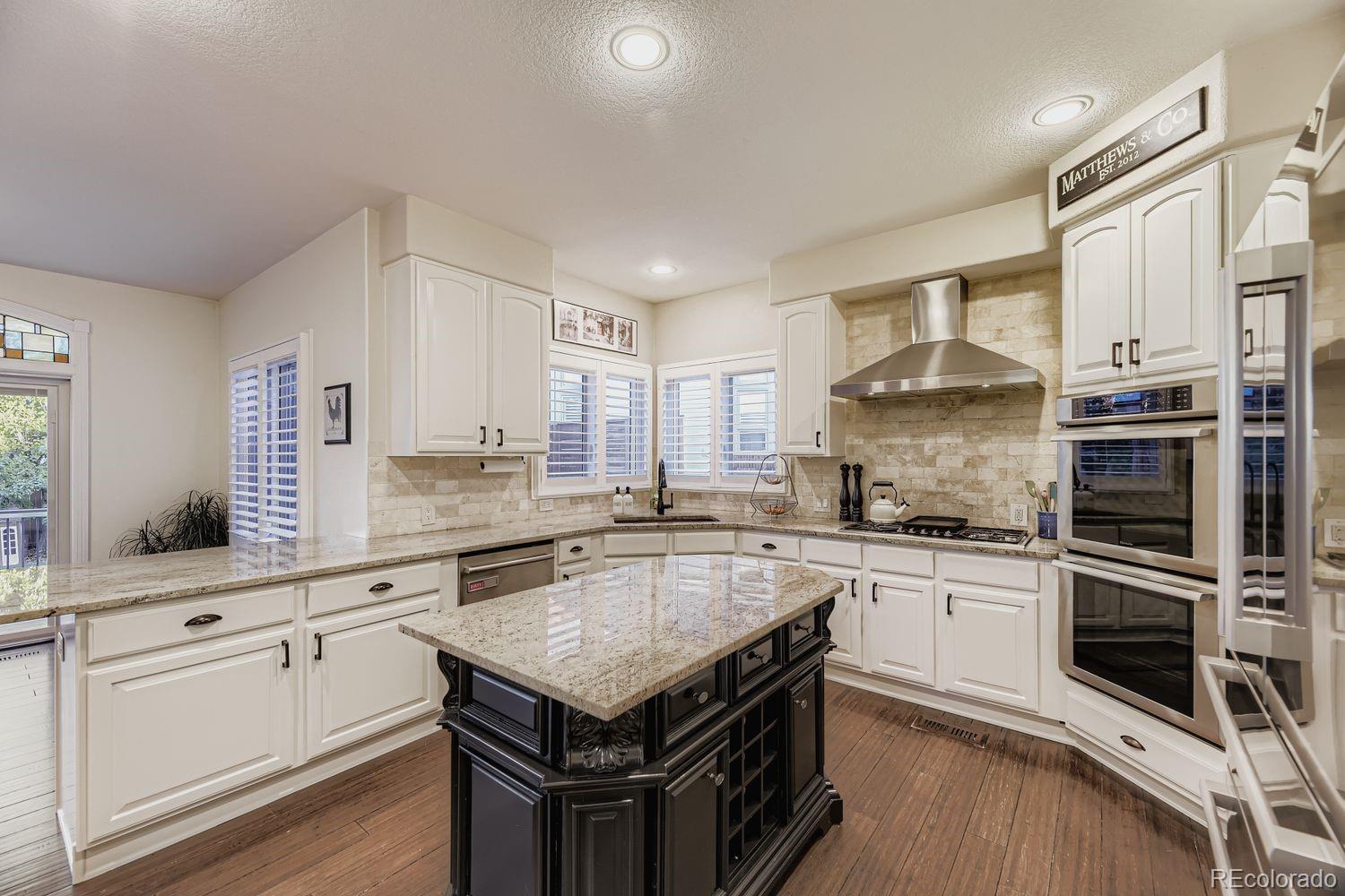 8356 Green Island Circle Lone Tree, CO 80124 - Photo 9 of 30 a kitchen with granite countertop a sink appliances cabinets and counter space