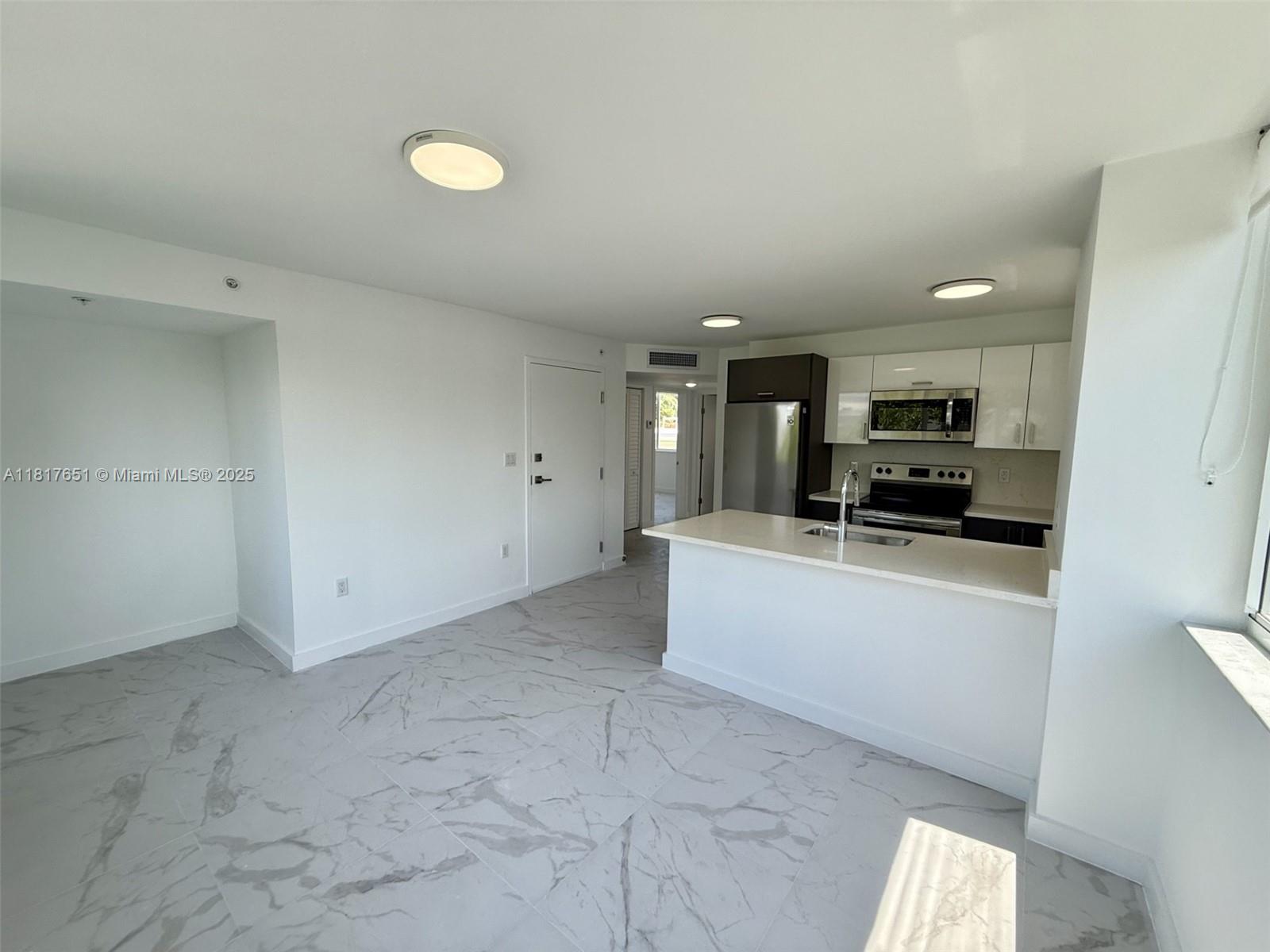 1552 Euclid Avenue, Unit 6 Miami Beach, FL 33139 - Photo 2 of 8 a view of kitchen with stainless steel appliances granite countertop a sink and cabinets