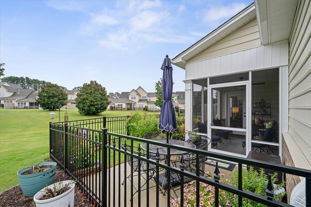 119 Shipyard Circle Anderson, SC 29621 - Photo 45 of 50 Relax on the concrete patio, complete with an umbrella-shaded table and a fenced yard overlooking a vibrant garden.