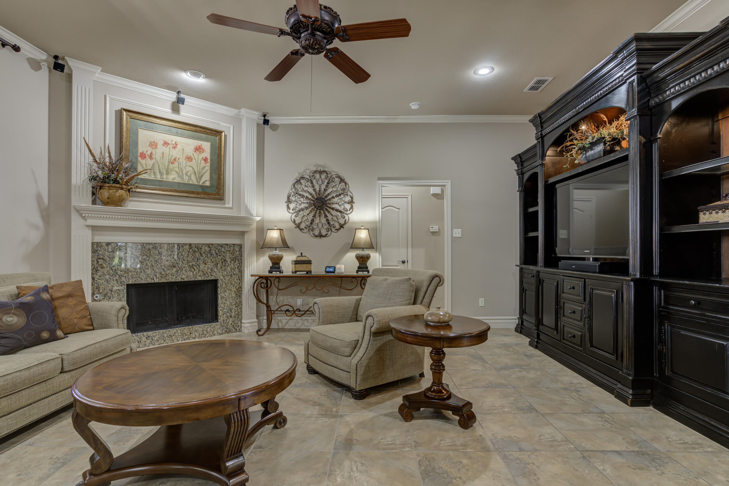 6008 89th Street Lubbock, TX 79424 - Photo 11 of 61 a living room with furniture a flat screen tv and a fireplace