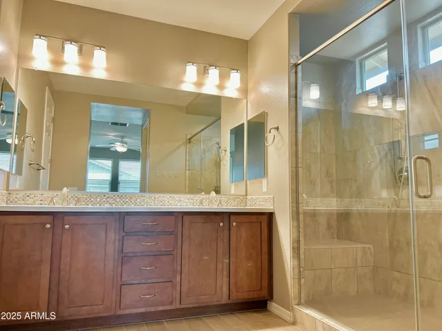 a bathroom with a granite countertop sink mirror and shower