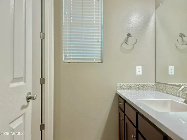 a bathroom with a granite countertop sink a mirror and a shower