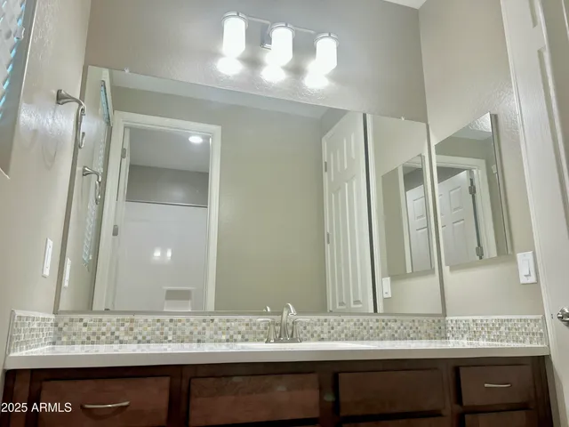 a bathroom with a granite countertop sink and a mirror