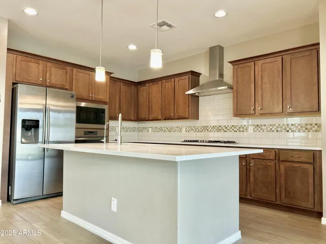 a kitchen with stainless steel appliances granite countertop a sink a stove and a refrigerator