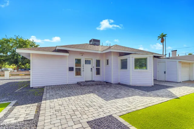 a view of a house with a yard and a large tree