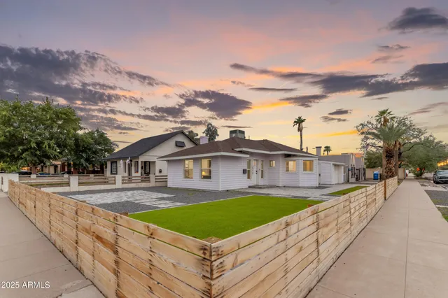 a front view of a house with a yard and mountain view in back