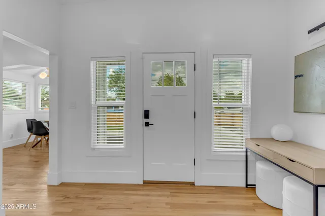 a view of an empty room with window and wooden floor