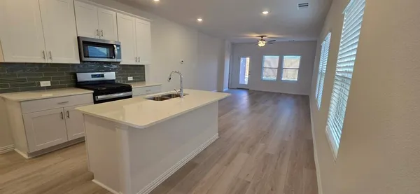 a kitchen with a sink stove and microwave