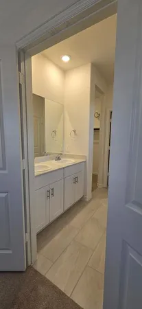 a spacious bathroom with a double vanity sink a mirror and a bathtub