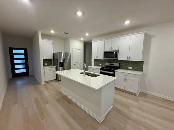 a kitchen with a sink stainless steel appliances and cabinets