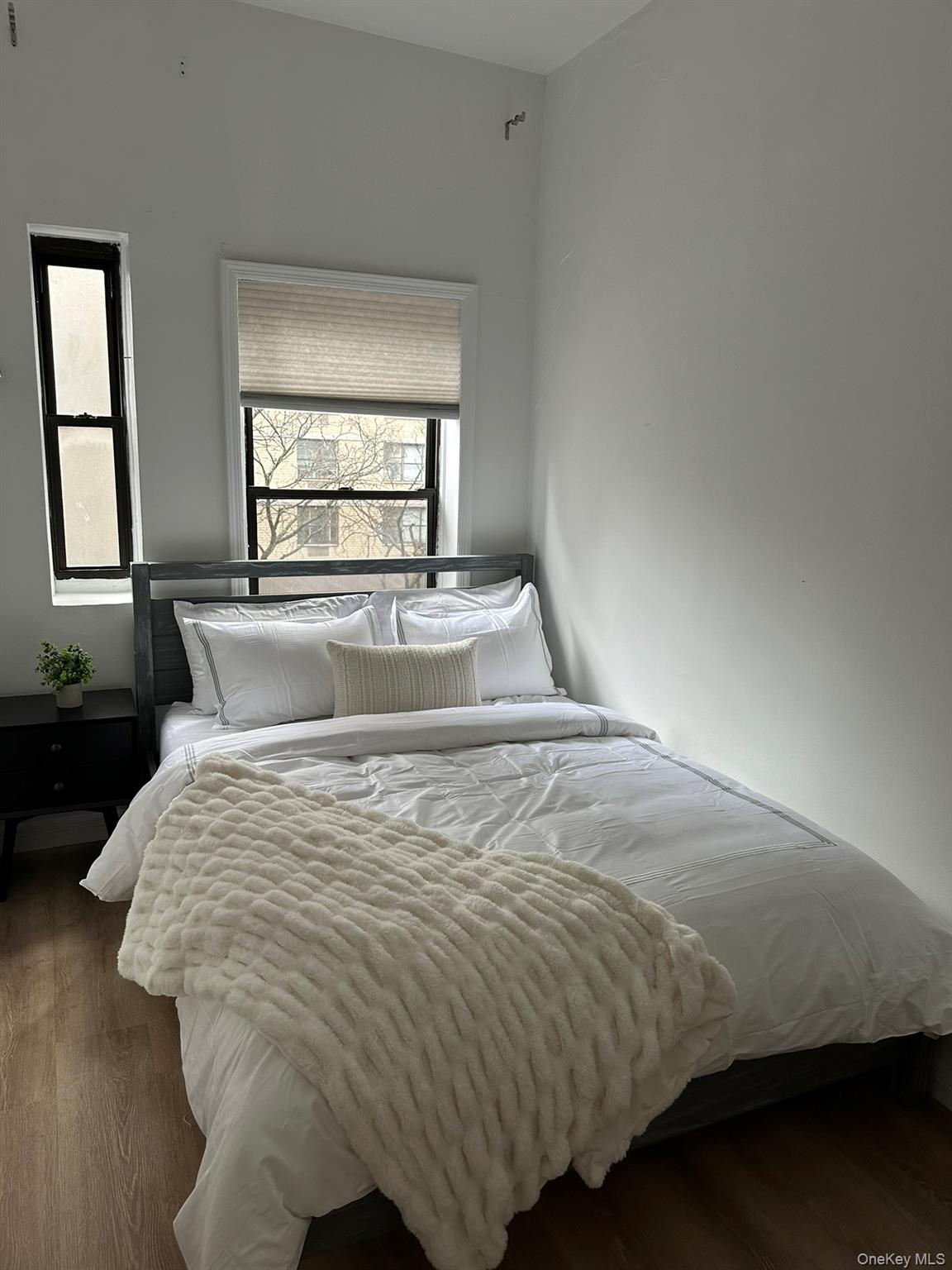 1435 2nd Avenue Manhattan, NY 10021 - Photo 29 of 33 a large bed sitting in a bedroom next to a window