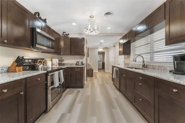 a large kitchen with stainless steel appliances lots of counter space and a sink