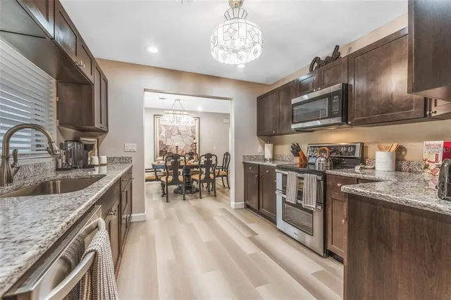 a kitchen with stainless steel appliances granite countertop a sink stove and refrigerator