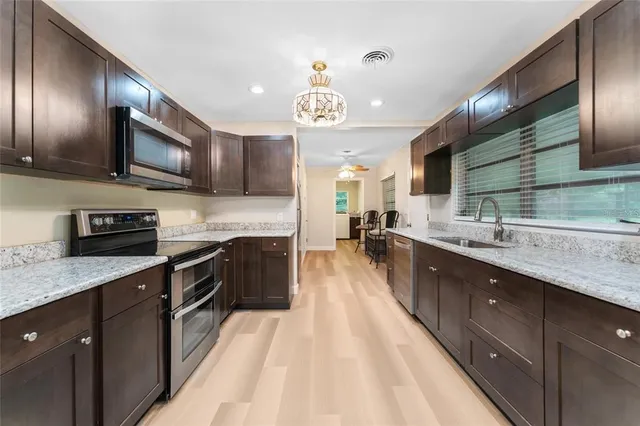 a large kitchen with stainless steel appliances kitchen island granite countertop a large stove top oven