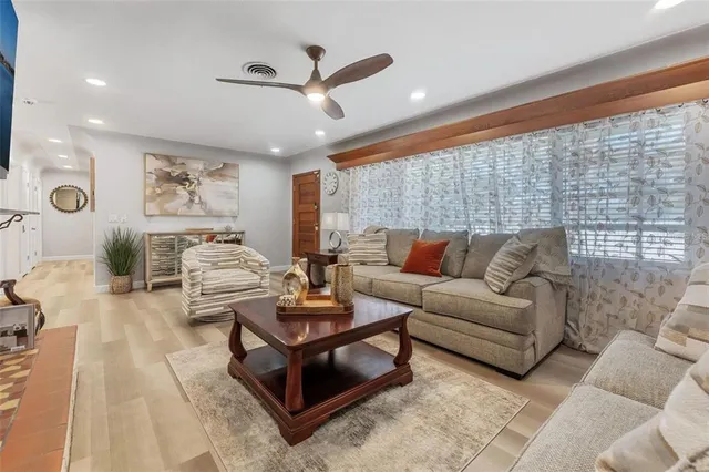 a living room with furniture and a ceiling fan