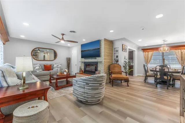 a living room with fireplace furniture and a large window