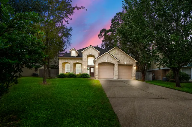 a front view of a house with a yard and trees