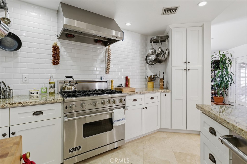 27843 Parker Road Castaic, CA 91384 - Photo 23 of 61 a kitchen with stainless steel appliances granite countertop white cabinets a stove a sink and a wooden floors