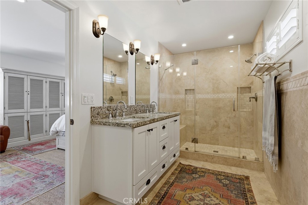 27843 Parker Road Castaic, CA 91384 - Photo 31 of 61 a bathroom with a granite countertop sink a mirror and a shower