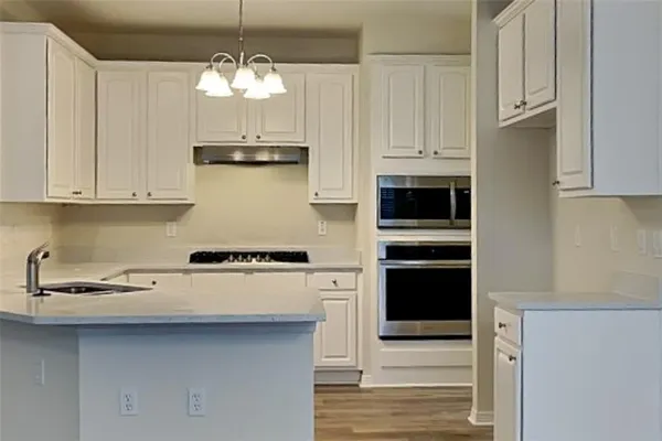 a kitchen with stainless steel appliances granite countertop a stove and a microwave