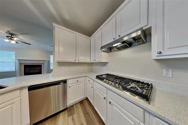 a kitchen with white cabinets and appliances