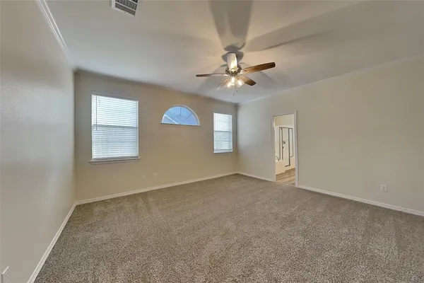 an empty room with windows and fan