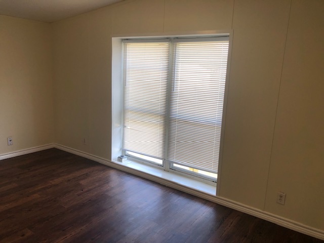 302 North Burnet Street Bremond, TX 76629 - Photo 16 of 41 an empty room with wooden floor and windows