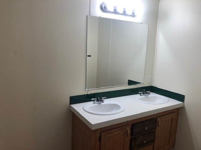 302 North Burnet Street Bremond, TX 76629 - Photo 22 of 41 a bathroom with a sink and a mirror