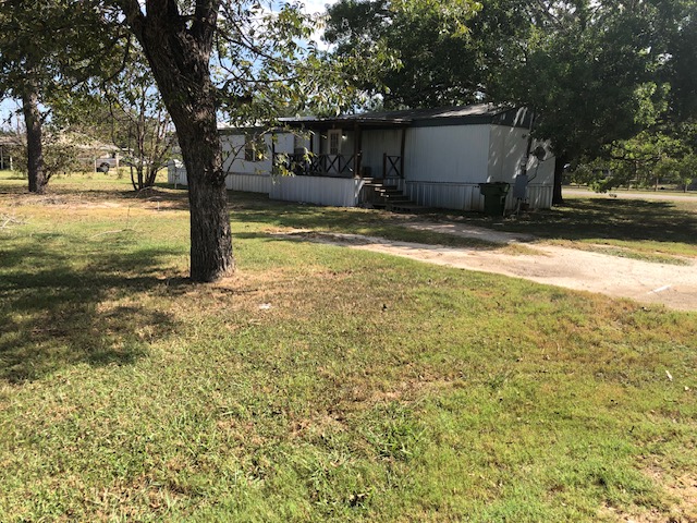 302 North Burnet Street Bremond, TX 76629 - Photo 29 of 41 a view of a backyard with a large tree