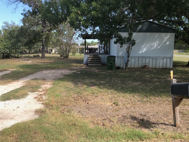 302 North Burnet Street Bremond, TX 76629 - Photo 41 of 41 a backyard of a house with barbeque oven table and chairs
