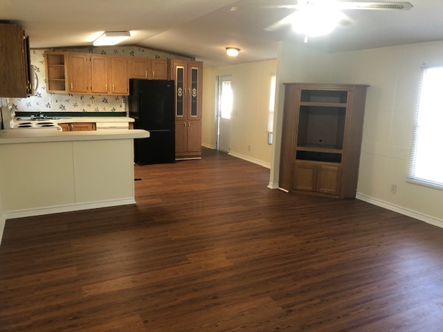 302 North Burnet Street Bremond, TX 76629 - Photo 7 of 41 a kitchen with kitchen island wooden floors appliances and cabinets