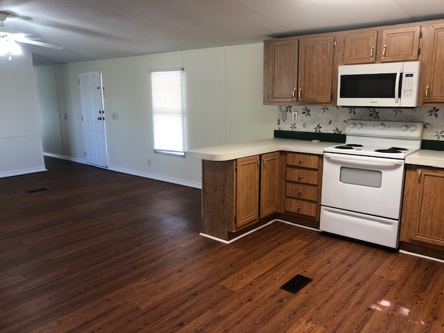 302 North Burnet Street Bremond, TX 76629 - Photo 9 of 41 a kitchen with stainless steel appliances granite countertop a stove a microwave oven a sink dishwasher and cabinets with wooden floor
