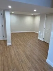 an empty room with wooden floor and white walls