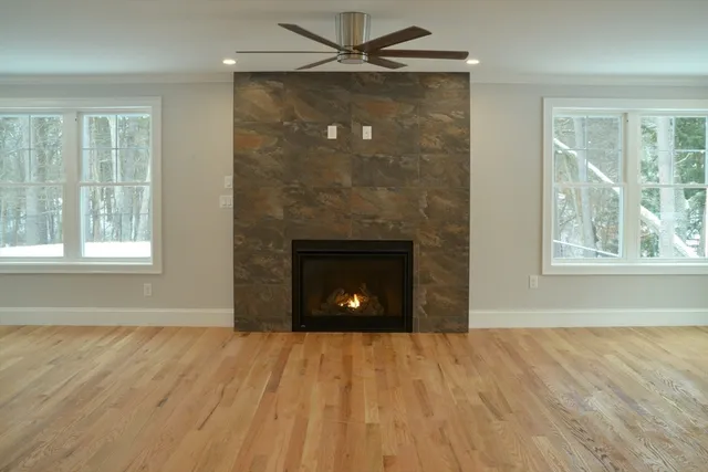 a view of an empty room with a window and a fireplace