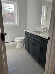 a bathroom with a sink a toilet and a window
