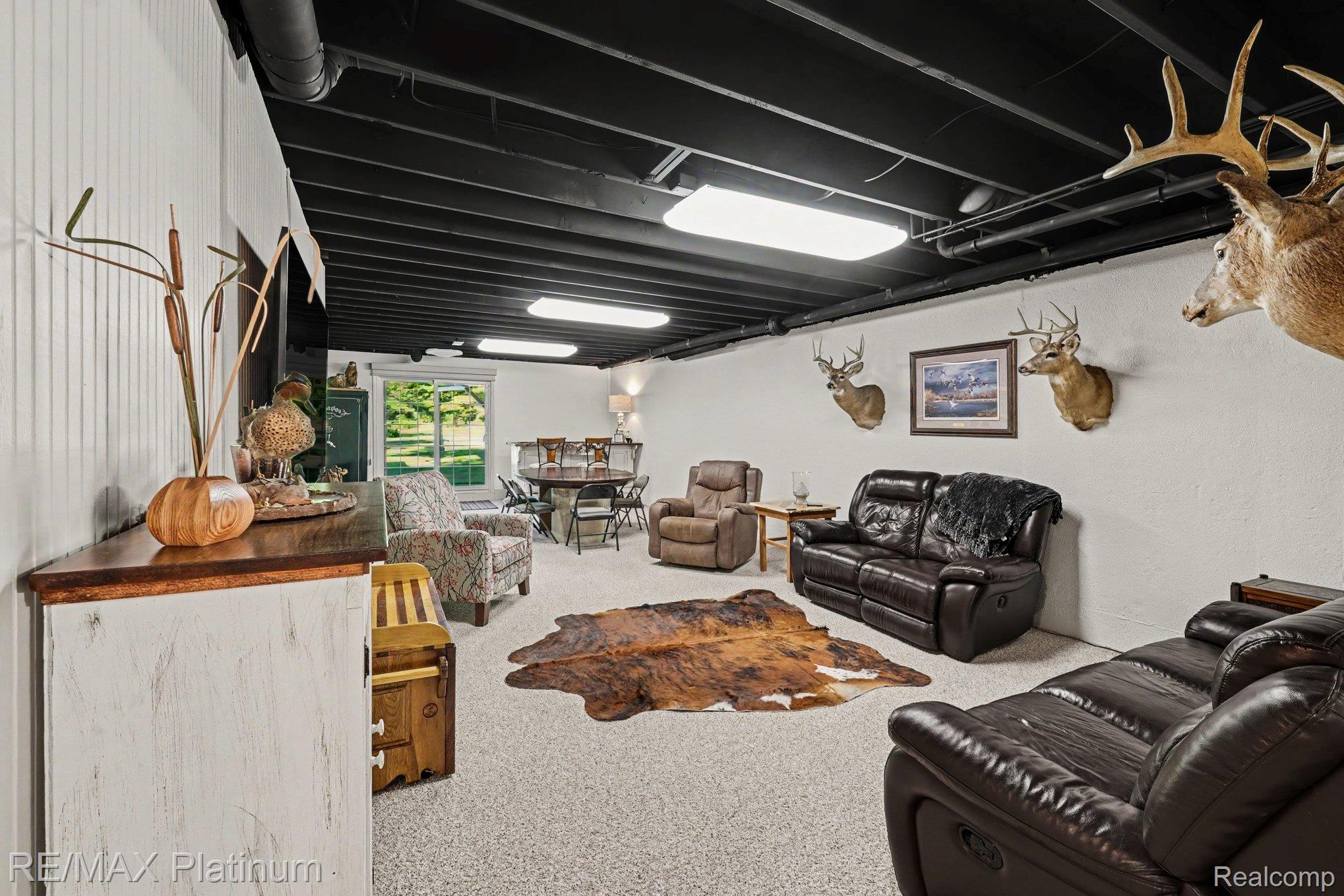 609 Telya Ridge Milford, MI 48381 - Photo 20 of 28 Spacious lower-level room featuring white walls, exposed black ceiling beams, and light-toned carpet flooring